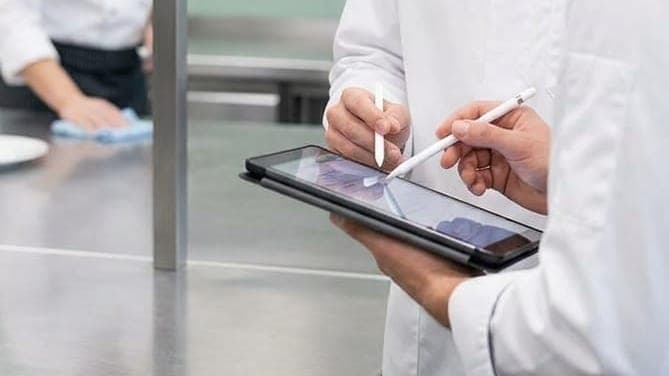 Kuisplan wordt op een tablet nagekeken in een professionele keuken